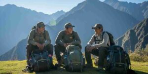 A group of smiling, well-equipped porters resting on a sunny mountain pass, an example of ethical and sustainable tourism in Peru.