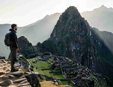 A lone hiker pausing on a high Andean pass during a transformative travel in Peru experience, looking out at a vast, sunlit mountain range, embodying a moment of deep reflection.